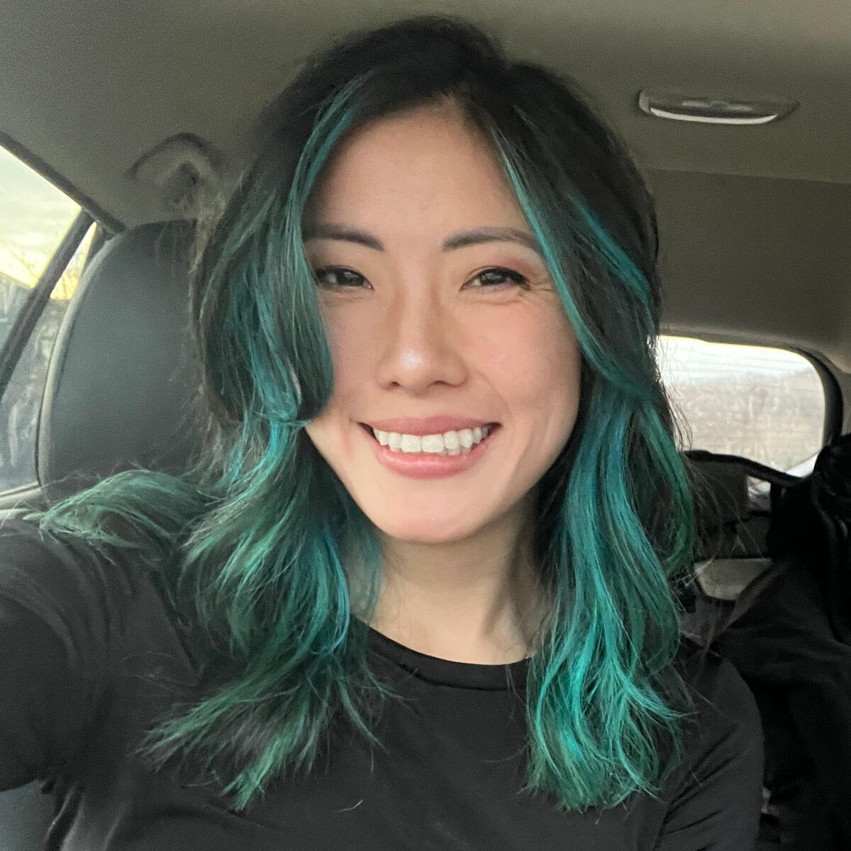 An Asian woman with black hair and teal streaks at the end.